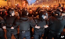 Riot police officers block the way to protesters during a rally in St. Petersburg, Russia, Oct. 7, 2017.