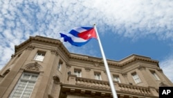 FILE - The Cuban flag is raised over their new embassy in Washington, July 20, 2015.