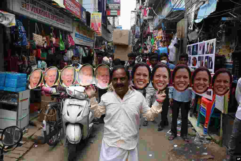 A man wearing cut-outs of U.S.President-elect Joe Biden and Vice President-elect Kamala Harris walks on a street in Chennai, India.