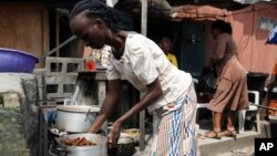 A woman prepares soup to sell on a street in Lagos, Nigeria, Aug. 7, 2014. 