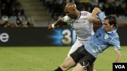 Nicolas Anelka berusaha merebut bola dari Diego Godin dalam pertandingan grup A Piala Dunia antara Uruguay dan Perancis di Cape Town. FFF menjatuhkan sanksi bagi Anelka atas ucapannya kepada pelatih pada partai melawan Meksiko.