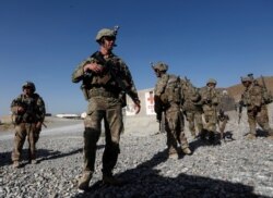 FILE - U.S. troops wait for their helicopter flight at an Afghan National Army (ANA) base in Logar province, Afghanistan, Aug. 7, 2018.
