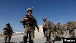 FILE - U.S. troops wait for their helicopter flight at an Afghan National Army (ANA) base in Logar province, Afghanistan, Aug. 7, 2018. 