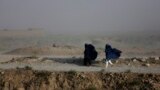 Women walk on a windy day outside Kabul, Afghanistan.