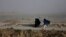 Women walk on a windy day outside Kabul, Afghanistan.