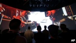 FILE - People watch the "Call of Duty: Advanced Warfare" video game trailer at the Activision booth at the Electronic Entertainment Expo in Los Angeles, June 12, 2014. 