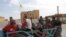People ride on the back of a truck at the border town of Tal Abyad, Syria, Oct. 14, 2019. 