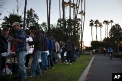 Homeless people wait in line for a free meal in Dana Point, California, Dec. 21, 2017.