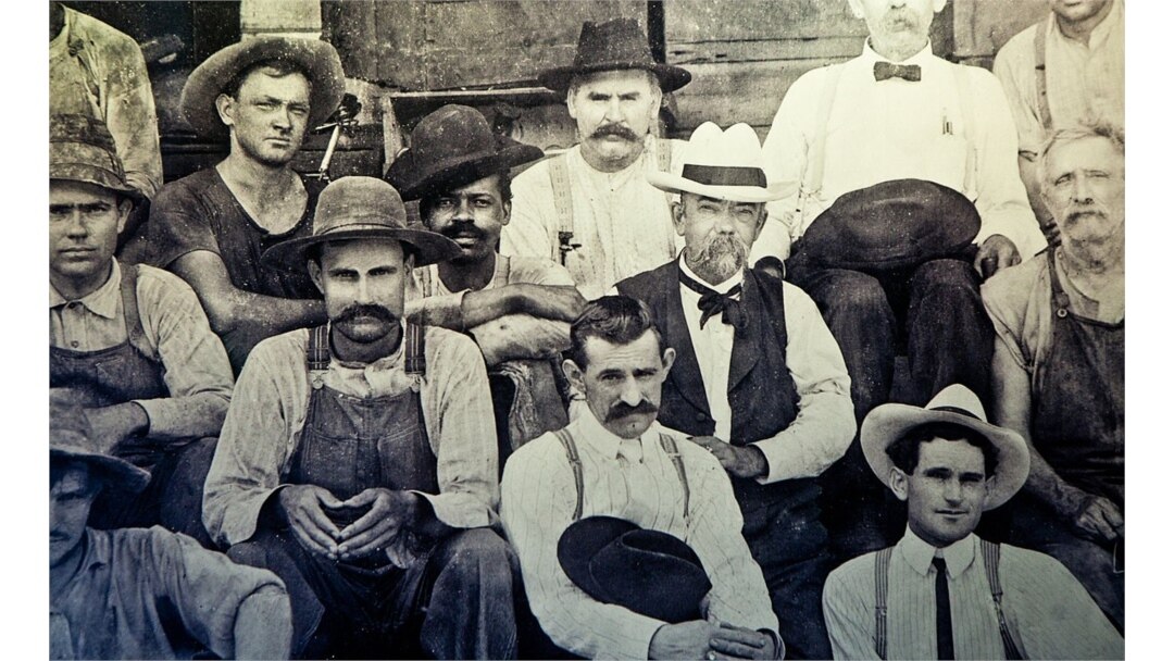 Historic photo of Jack Daniel (in white hat) seated next to George Green, the son of Nathan "Nearest" Green.