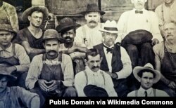 Historic photo of Jack Daniel (in white hat) seated next to George Green, the son of Nathan "Nearest" Green.