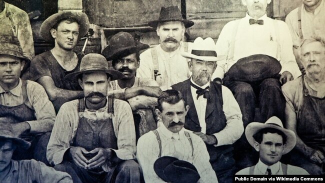 Foto histórica de Jack Daniel (con sombrero blanco) sentado junto a George Green, el hijo de Nathan "Nehest" Green.
