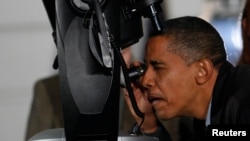 FILE - U.S. President Barack Obama looks through a telescope during an event to look at the stars with local middle school students and astronomers from across the country on the South Lawn at the White House in Washington, October 7, 2009.