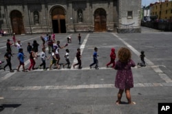 Central America migrant children play on the plaza of the Santa Cruz y La Soledad Catholic parish church, in La Merced neighborhood of Mexico City, July 8, 2024.