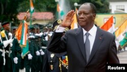 Ivory Coast's President Alassane Ouattara salutes during a parade to commemorate the country's 54th Independence Day, outside the presidential palace in Abidjan, Aug. 7, 2014.