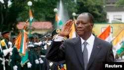 Ivory Coast's President Alassane Ouattara salutes during a parade to commemorate the country's 54th Independence Day, outside the presidential palace in Abidjan, August 7, 2014.