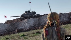 ທະ​ຫານ​ບ້ານ ຈາກກອງ​ກຳ​ລັງ​ປົກ​ປ້ອງປະ​ຊາ​ຊົນ​ຊາວ​ເຄີດ​ໃນ​ຊີ​ເຣຍ ຫຼື YPG ລາດ​ຕະ​ເວນ ຢູ່​ບ້ານ​ເອ​ສ​ເມ ໃນ​ແຂວງ​ອາ​ເລັບ​ໂປ ​ປະ​ເທດ​ຊີ​ເຣຍ ເມື່ອ​ວັນ​ທີ 22 ກຸມ​ພາ 2015.