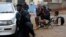 A policeman and photographers take cover after hearing gun shots near the Westgate shopping mall in Nairobi on Sept. 23, 2013. 