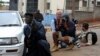 A policeman and photographers take cover after hearing gun shots near the Westgate shopping centre in Nairobi, Sept. 23, 2013. 