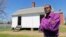 FILE - Rev. Alfred L. Jones III poses in front of the reconstructed slave quarters behind the McLean House on the grounds of Appomattox Court House National Historical Park in Appomattox, Va., April 1, 2015.