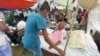 Una mujer es atendida por un miembro del personal médico afuera de un hospital después del terremoto de magnitud 7,2 del sábado, en Les Cayes, Haití, el 16 de agosto de 2021.