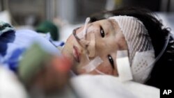 Xiang Weiyi lies in a hospital bed after she was the last survivor rescued some 21 hours after a Chinese high-speed train crash in eastern China's Zhejiang province, July 25, 2011