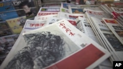 A New Year edition of Southern Weekly, center, published on January 3, 2013, is exhibited at a newsstand in Beijing, China, January 4, 2013. 