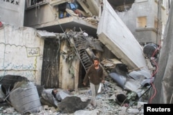 A Palestinian man walks outside a house hit in an Israeli strike, amid the ongoing conflict between Israel and Hamas, in Gaza City, Nov. 21, 2024.