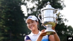 Pemain golf Korea Selatan In Gee Chun memegang piala turnamen golf AS Terbuka Putri di Lancaster Country Club (12/7) di Lancaster, Pennsylvania. (AP/Gene J. Puskar)