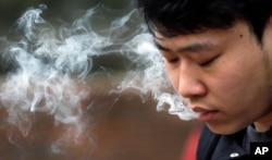 David Wang, 19, smokes outside during a break from classes at Seattle Central College in Seattle, Washington, Jan. 7, 2016.