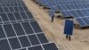 2012年5月18日新疆維吾爾自治區阿克蘇市一家太陽能發電廠的員工搬運太陽能電池板