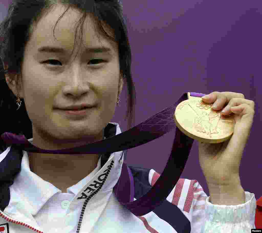 South Korea's Ki Bo-bae celebrates on the podium after her gold win over Mexico's Aida Roman during the individual archery competition at the 2012 Summer Olympics, Aug. 2, 2012, in London. 