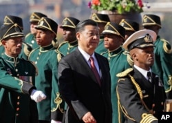 Chinese President Xi Jinping, center, inspects the honor guard during an official welcoming ceremony at the government's Union Buildings in Pretoria, South Africa, July 24, 2018.
