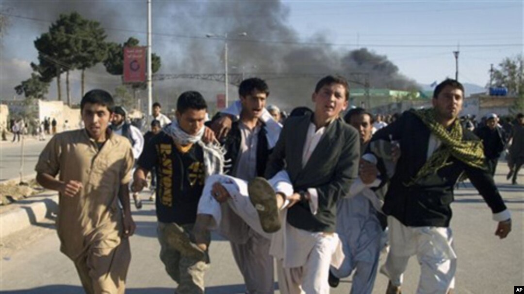 Afghans carrying a man, who got wounded following an attack on UN's office during a demonstration to condemn the burning of a copy of the Muslim holy book by a Florida pastor, in Mazar-i- Sharif north of Kabul, Afghanistan on April. 1, 2011.