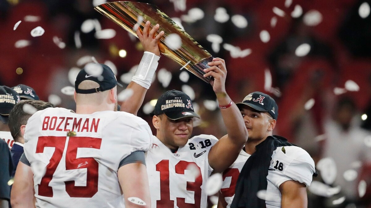 Tua Tagovailoa Alabama Crimson Tide Unsigned White Jersey Raising Up National Championship Trophy Photograph