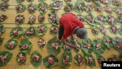 Seperti di Solo, sebuah masjid di Yogykarta juga menggunakan daun untuk membungkus daging-daging kurban sebelum dibagikan dalam rangka Iduladha, 11 Agustus 2019. (Foto: Antara/Andreas Fitri via Reuters)