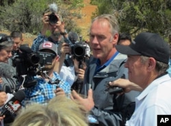 FILE - Interior Secretary Ryan Zinke, second from right, speaks during a press conference near Blanding, Utah, May 8, 2017.