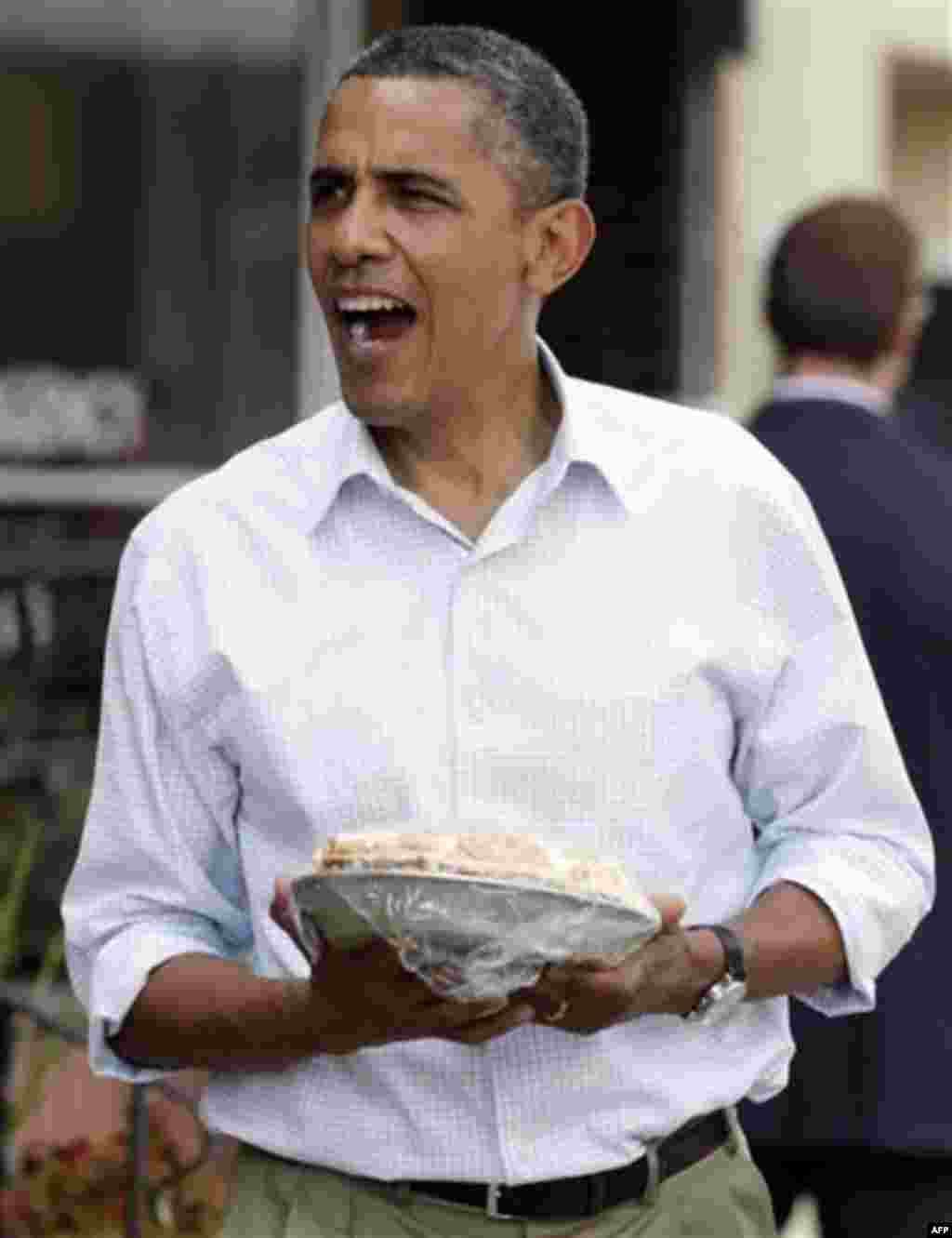 In this Aug. 15, 2011, photo, President Barack Obama walks out of The Coffee Mill Restaurant, Monday, Aug. 15, 2011, in Zumbrota, Minn., with a pie. As Obama made his way through a three-day, three-state presidential trip in the Midwest, pies, ice cream, 