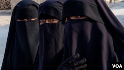 Three women from Iraq keep their niqabs inside al-Hol Camp, the largest detention center for people accused of being part of IS in Northeast Syria, on Oct. 12, 2024. (Diego Baravelli/VOA)