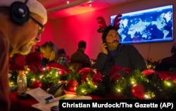 Volunteers answer phone calls from around the world, Dec. 24, 2024, at the NORAD Tracks Santa center at Peterson Space Force Base in Colorado Springs, Colodo.