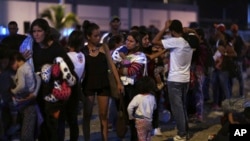 FILE - Venezuelans wait to pass immigration control at the Ecuador-Peru border, before the deadline on stricter regulations that require passports, in Tumbes, Peru, June 14, 2019. 