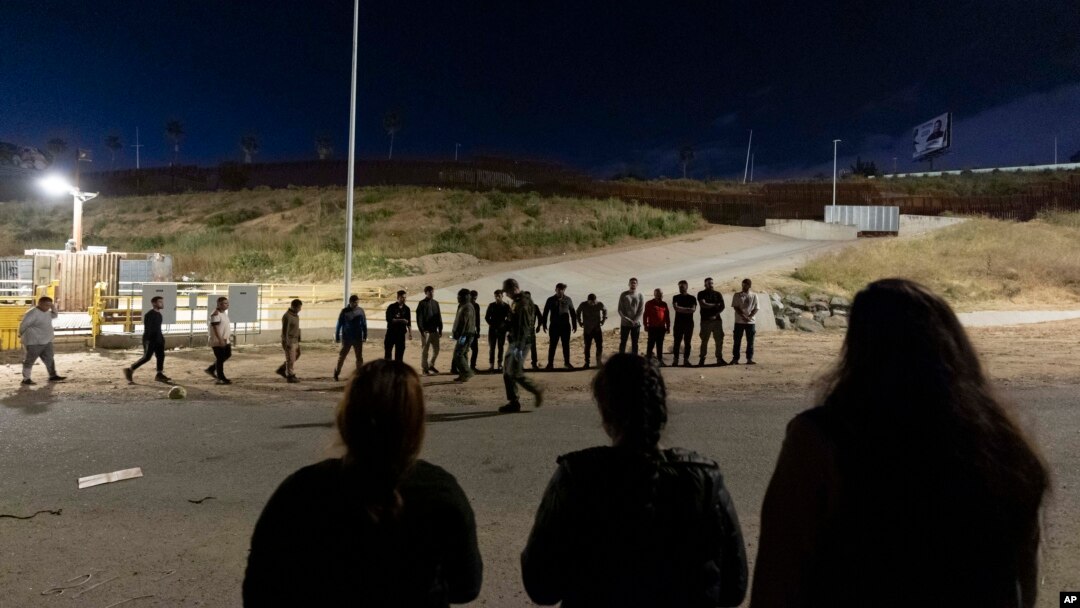 Migranti postrojeni duž graničnih zidova koji razdvajaju Tihuanu, Meksiko i San Dijego, kako bi podnijeli zahtjev za azil kod američkih vlasti, 7. maja 2024. u San Diegu.