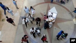 FILE- Shoppers walk through Dolphin Mall on Black Friday in Miami, Nov. 23, 2018. On Tuesday, Jan. 29, 2019, the Conference Board releases its January index on U.S. consumer confidence.