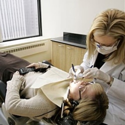 A dentist in Chicago works on the teeth of one of her patients