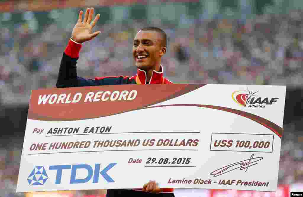 Ashton Eaton of the U.S. gestures as he holds a giant $100,000 cheque for his world record in the men&#39;s decathlon during the 15th IAAF World Championships at the National Stadium in Beijing, China.