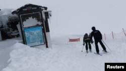 Dua orang pemain ski tengah beristirahat dari Peak Rosa, setelah mendapat peringatan meningkatnya 'avalanche' di resor Rosa Khutor, Sochi, tempat penyelenggaraan Olimpiade Musim Dingin 2014 yang baru saja berakhir. 