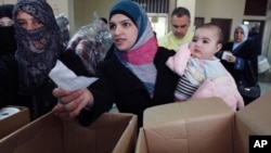 Syrian refugees receive humanitarian aid from an Islamic organization in Tripoli, Lebanon, March 6, 2012. 