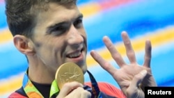 Vận động viên Michael Phelps của Mỹ ra dấu cho biết anh đã giành 4 huy chương vàng ở Olympic 2016.