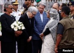Bangladesh's Prime Minister Sheikh Hasina (2nd R) talks to Japanese ambassador to Bangladesh Masato Watanabe (2nd L) after paying homage to the victims who were killed in the attack on the Holey Artisan Bakery and O'Kitchen Restaurant.