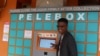 Inventor Neo Hutiri poses in front of one of his Peleboxes. (T. Khumalo/VOA)