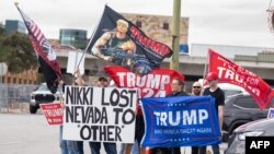 Para pendukung Trump berkumpul di jalan sambil membawa poster di luar acara kampanye bersama Duta Besar PBB dan calon presiden AS dari Partai Republik Nikki Haley di San Antonio, Texas, 16 Februari 2024. (Foto: SUZANNE CORDEIRO / AFP)